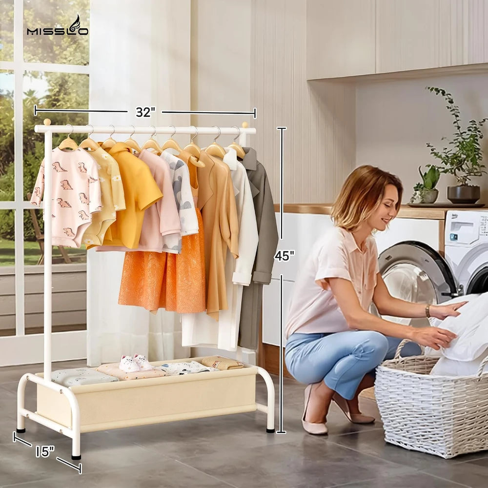 A & M BOUTIQUE white kids clothing rack with a bottom storage basket, holding various children's outfits in a room.